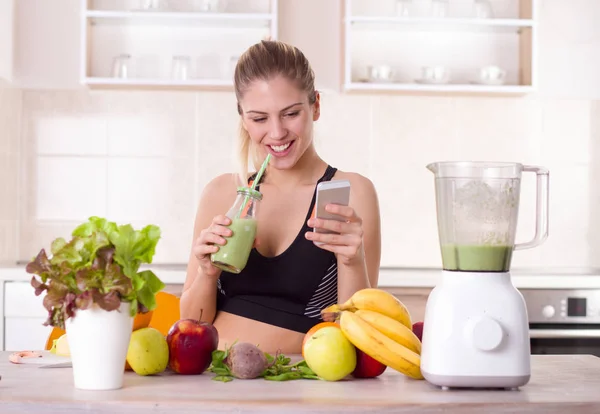 Menina bebendo smoothie na cozinha — Fotografia de Stock