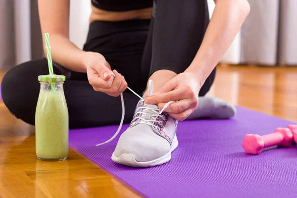 Deportiva mujer atando cordones en el suelo — Foto de Stock