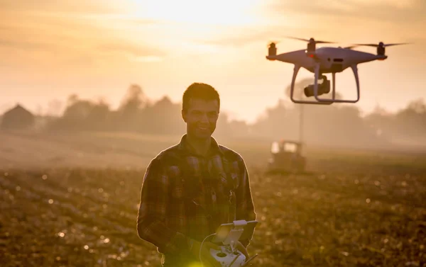 Farmer navigating drone above farmland