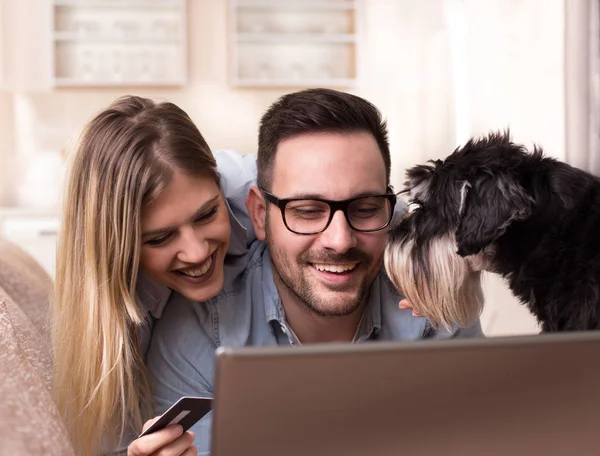 Coppia giovane con cane shopping online a casa — Foto Stock