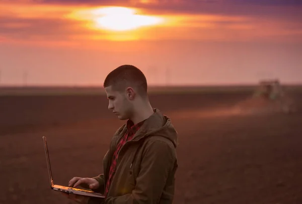 Bonde med laptop på fältet — Stockfoto