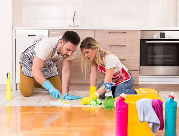 Jong paar schoonmaken huis samen — Stockfoto