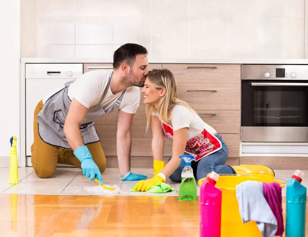 Jeune couple nettoyage maison ensemble et avoir des moments tendres — Photo