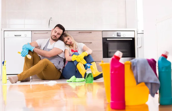 疲惫的年轻夫妇在做家务后坐在地板上 — 图库照片