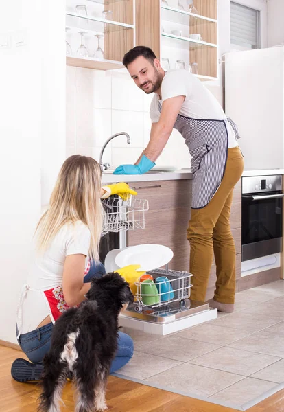 Happy couple unloading dishwasher — Stock Photo, Image