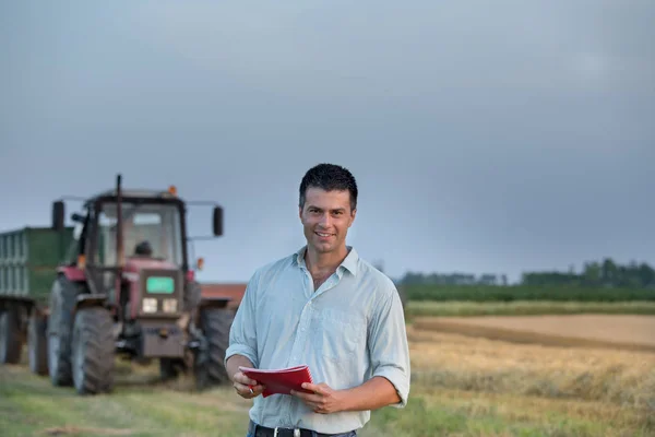 Boer en trekker in veld — Stockfoto