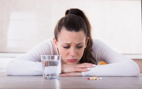 Mulher sentindo-se triste por causa de comprimidos — Fotografia de Stock