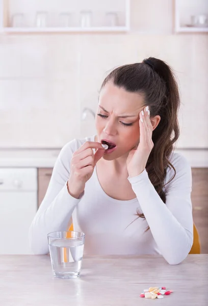 Mujer tomando pastillas para el dolor de cabeza — Foto de Stock