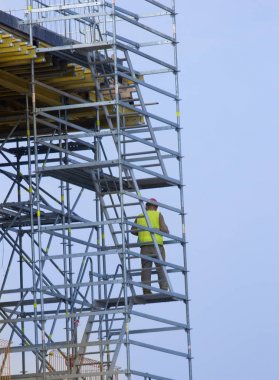 İskele merdivenlerde inşaat işçisi