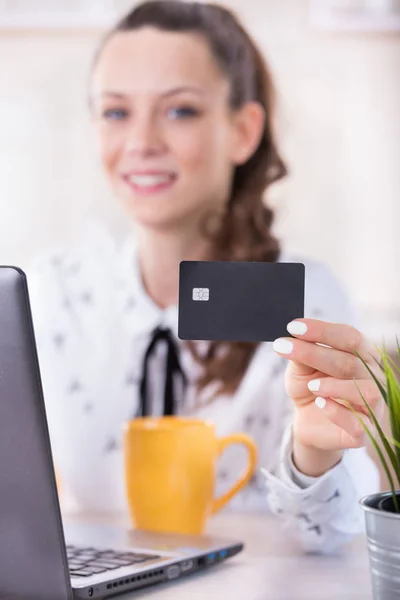 Mujer mostrando tarjeta de crédito en la mesa — Foto de Stock