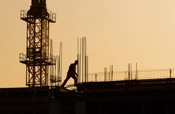 Trabajadores de la construcción en obra al atardecer —  Fotos de Stock
