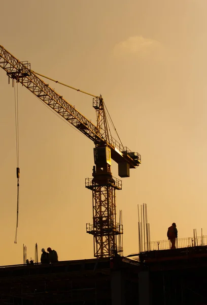 Byggnadsarbetare på byggnadsplatsen vid solnedgången — Stockfoto