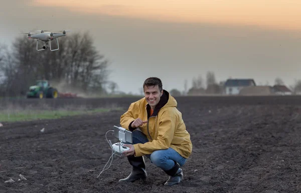Boer navigeren drone boven landbouwgrond — Stockfoto