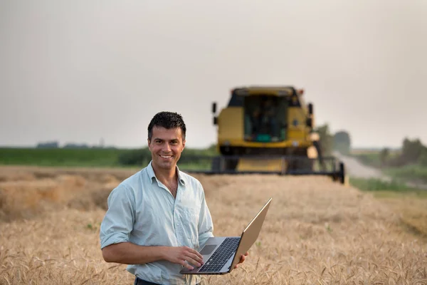 Engenheiro com laptop e colheitadeira — Fotografia de Stock