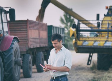 Traktör ve birleştirmek hasat hasat sırasında önünde çiftçi