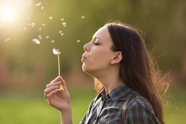 Woman blowing dandelion flower — Stock Photo, Image