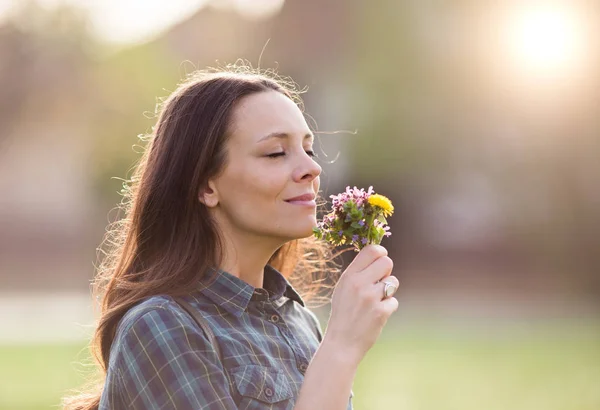 Pretty woman smelling flowers — Stock Photo, Image
