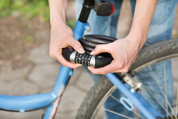 Woman locking bicycle with combination lock — Stock Photo, Image