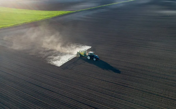 Tractor rociando tierra en el campo — Foto de Stock