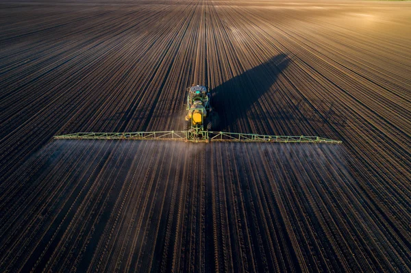 Tractor rociando tierra en el campo —  Fotos de Stock