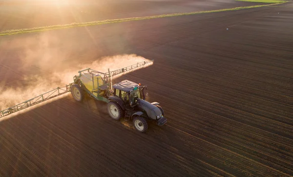 Traktor sprüht Erde auf Feld — Stockfoto