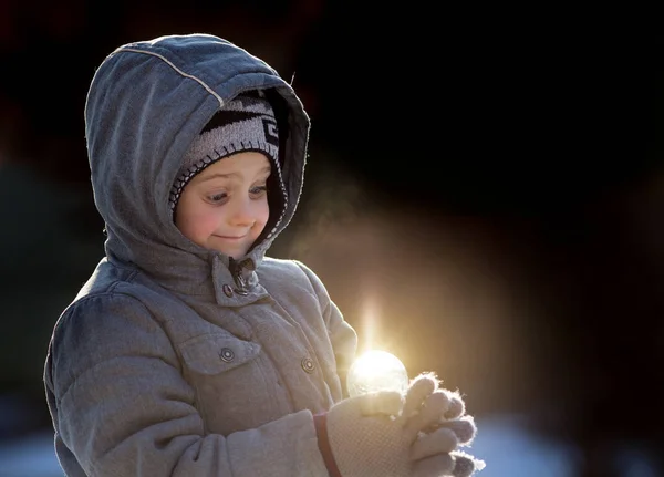 Junge mit magischer Lichtkugel auf Schnee — Stockfoto