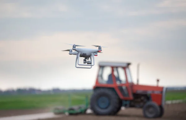 Drohne vor Traktor auf Feld — Stockfoto