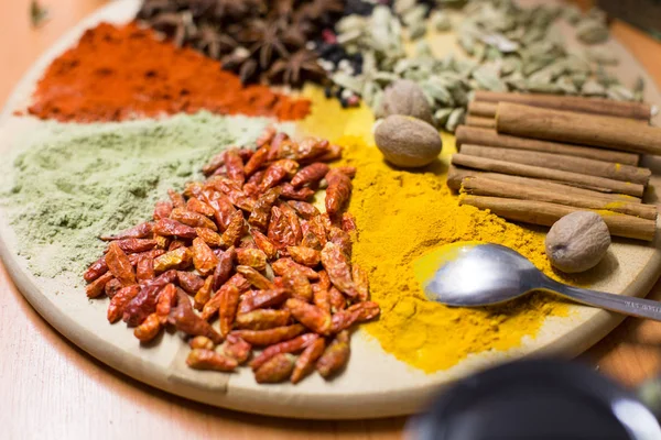 Colorful spices on wooden plate — Stock Photo, Image