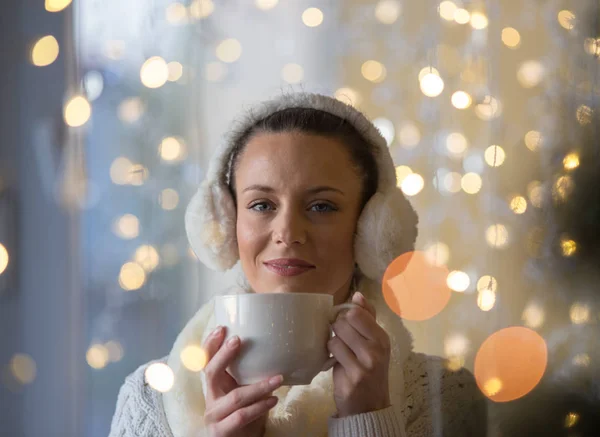 Mädchen mit Tasse Kaffee in weihnachtlichem Ambiente — Stockfoto