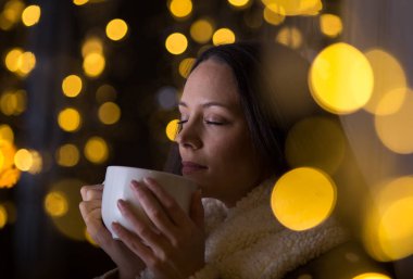 Noel ortamında çay içen kız.