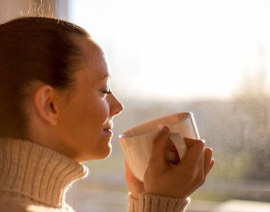 Pencerenin yanında kahve içen kız