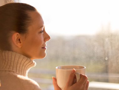 Pencerenin yanında kahve içen kız