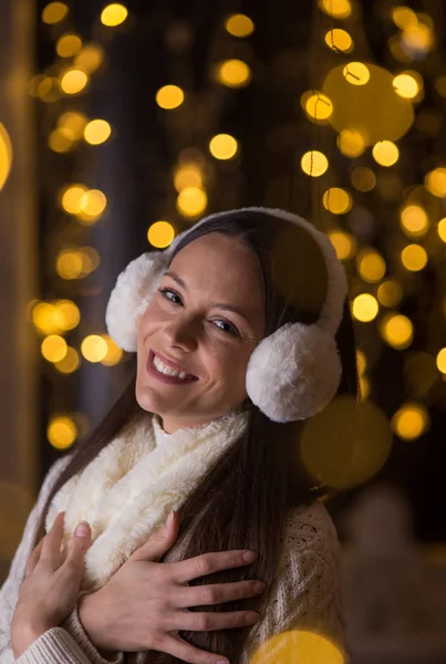 Mädchen mit Ohrenschützern und Weihnachtsbeleuchtung — Stockfoto