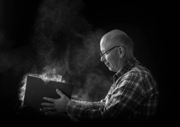 Старик с пыльной книгой — стоковое фото