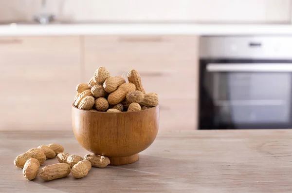 Cacahuetes en cáscaras en tazón en la cocina —  Fotos de Stock