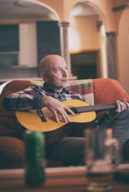 Yaşlı adam evde gitar çalmak