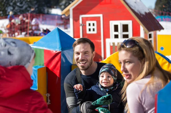 Eltern mit Jungen basteln Schneemann am Berg — Stockfoto