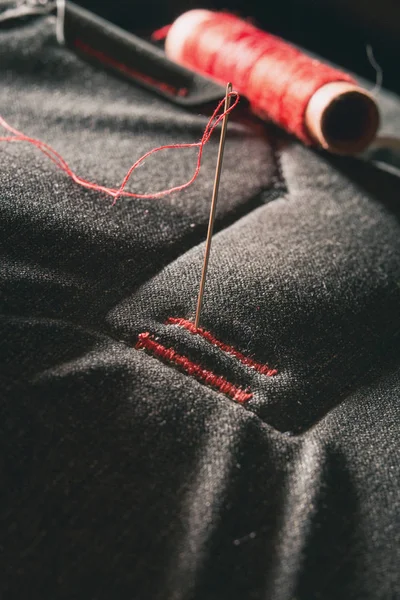 Czerwona nitka na szarej tkaninie — Zdjęcie stockowe