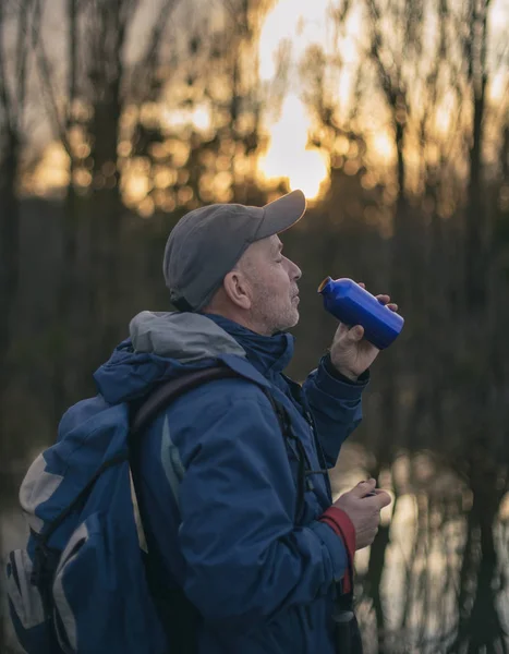 Wanderer trinkt Wasser im Wald — Stockfoto