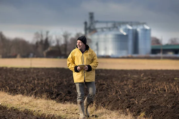 Agricultor com comprimido no campo — Fotografia de Stock