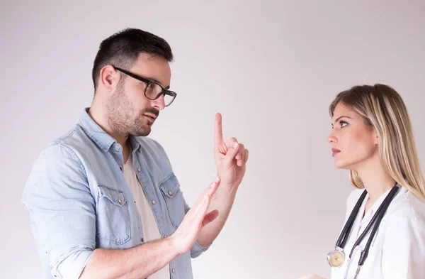 Patient and doctor having argument — 스톡 사진