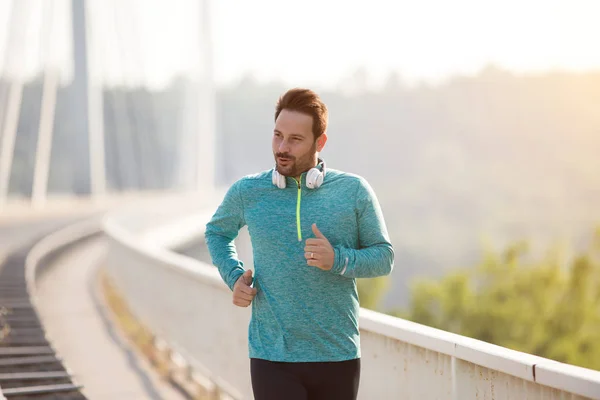 Homme jogging sur le pont le matin — Photo