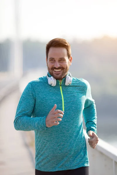 Homme jogging sur le pont le matin — Photo