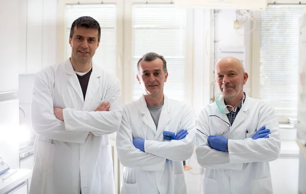 実験室でポーズをとっている経験豊かな3人の生物学者のチーム — ストック写真