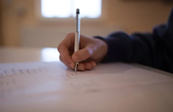 若い女の子の手のペンを保持し テーブルでノートを書きます — ストック写真