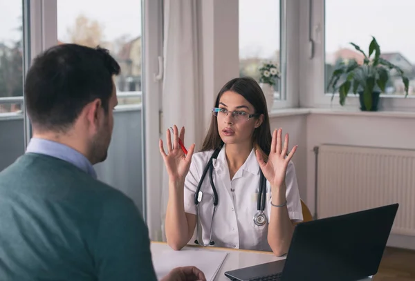 Junge Ärztin Erklärt Einer Patientin Schreibtisch Der Klinik Etwas — Stockfoto