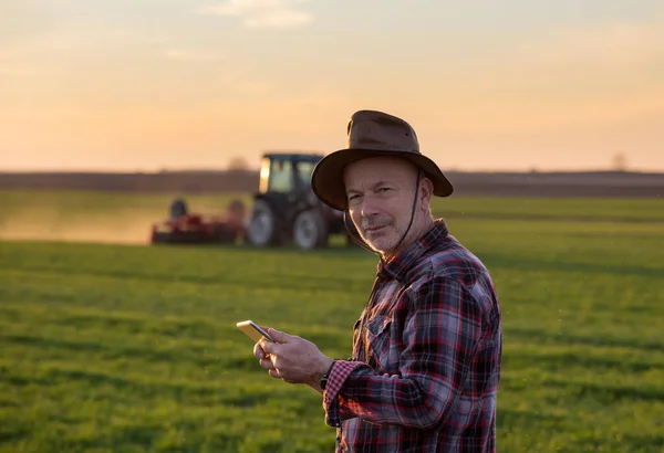 Retrato Agricultor Sênior Com Chapéu Segurando Tablet Campo Enquanto Trator — Fotografia de Stock