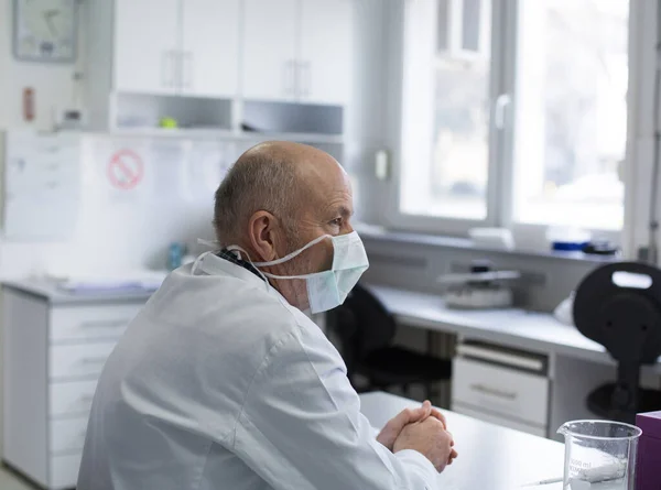 Médico Sênior Com Máscara Protetora Sentado Mesa Laboratório — Fotografia de Stock