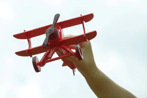 Kinderhand hält handgefertigtes Flugzeug aus Holz — Stockfoto