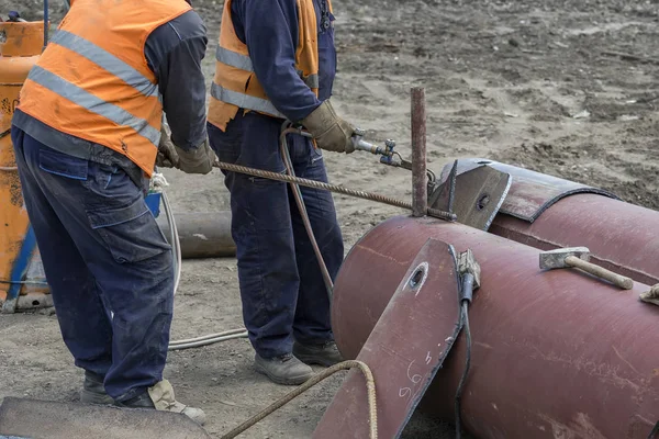 Barre metalliche piegate dai lavoratori con torcia a fiamma — Foto Stock